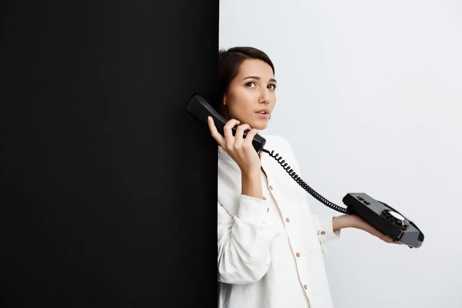 a woman wearing a white longsleeve calling for phone system installation for small business